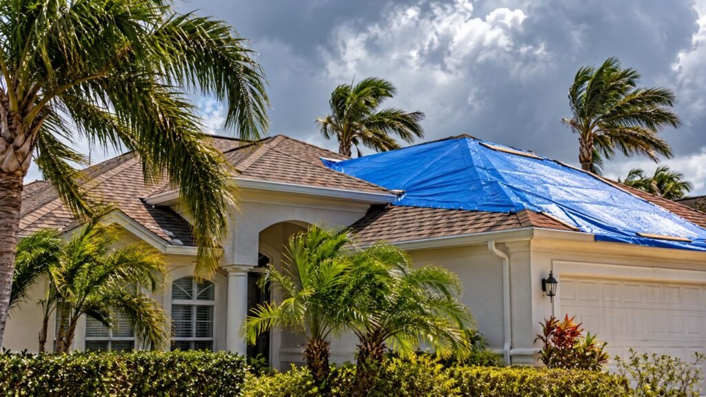 Florida home with a blue tarp on the roof after a storm